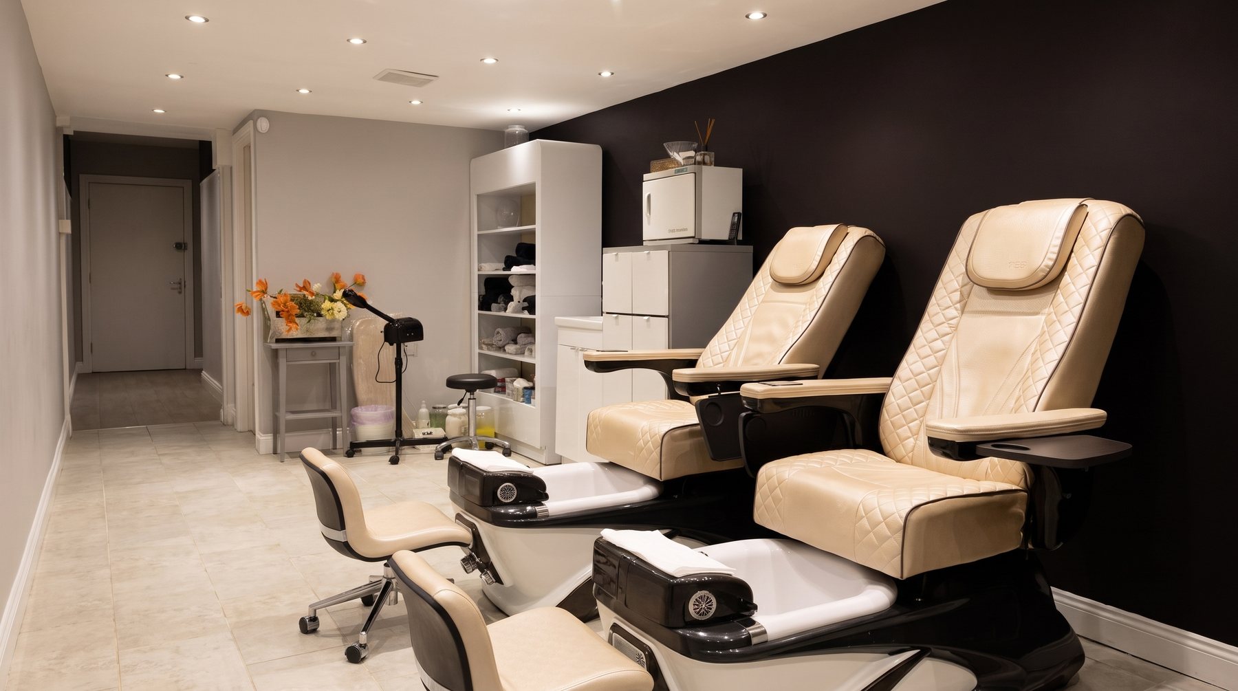 The pedicure room: two cream pedicure chairs against the navy wall