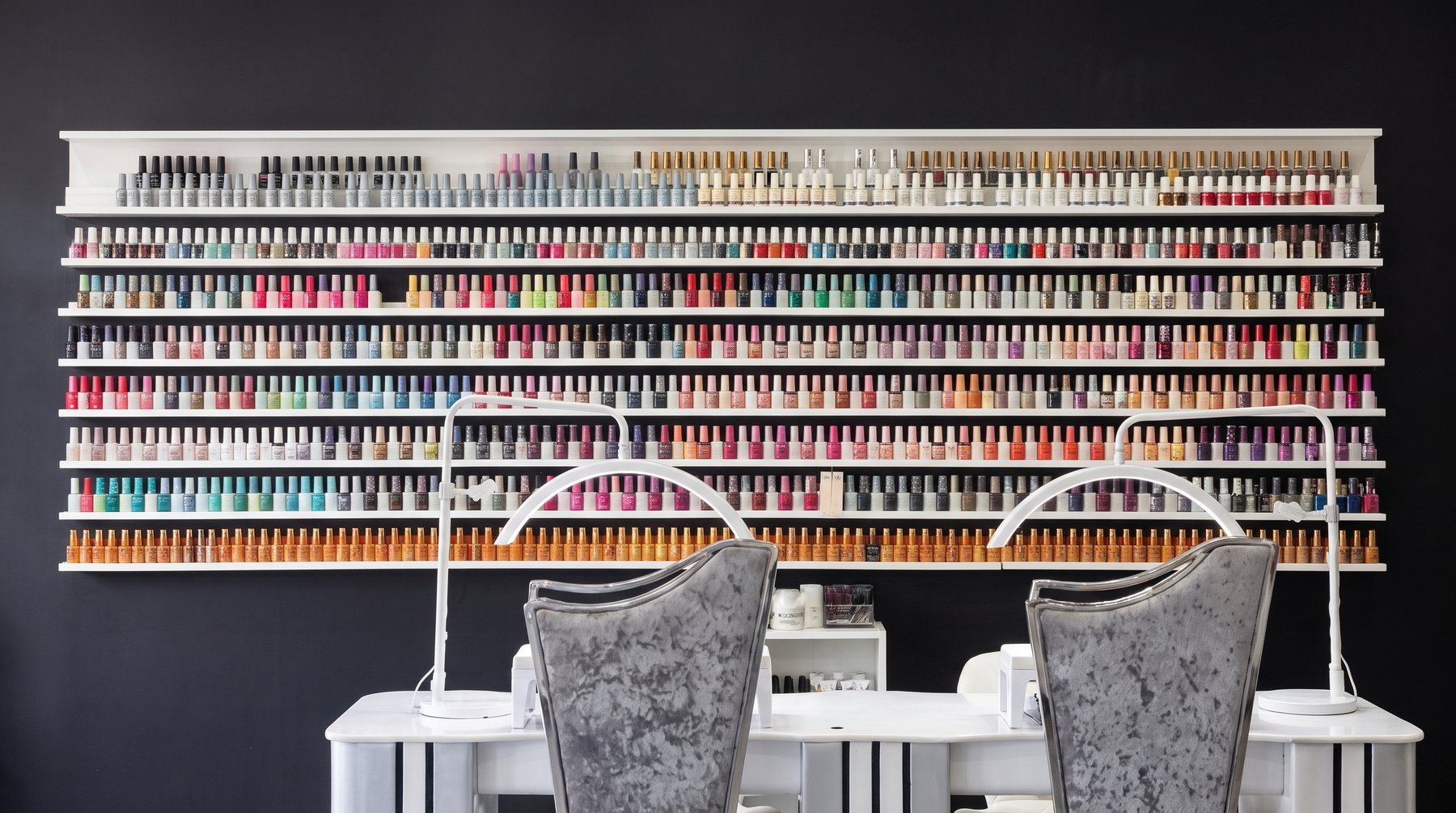 The wall of gel polish colours above the nail desks
